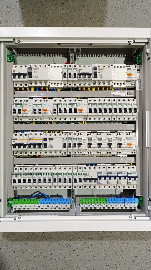 Щит Schneider Electric Acti9 на стене: четыре ряда аппаратуры, нумерация групп, шины N и PE